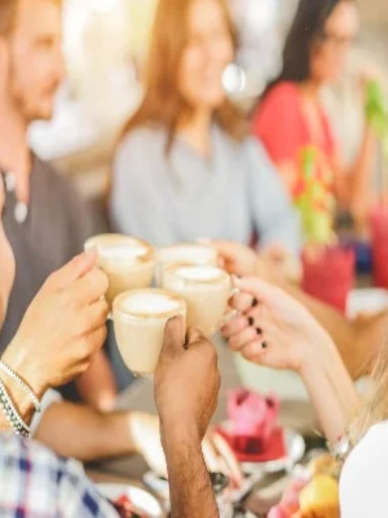 Four people celebrating with a coffee each