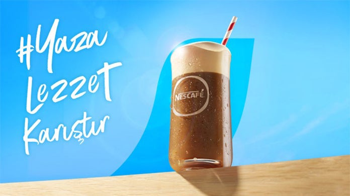 Masanın üzerinde NESCAFÉ Frappé bardağı
