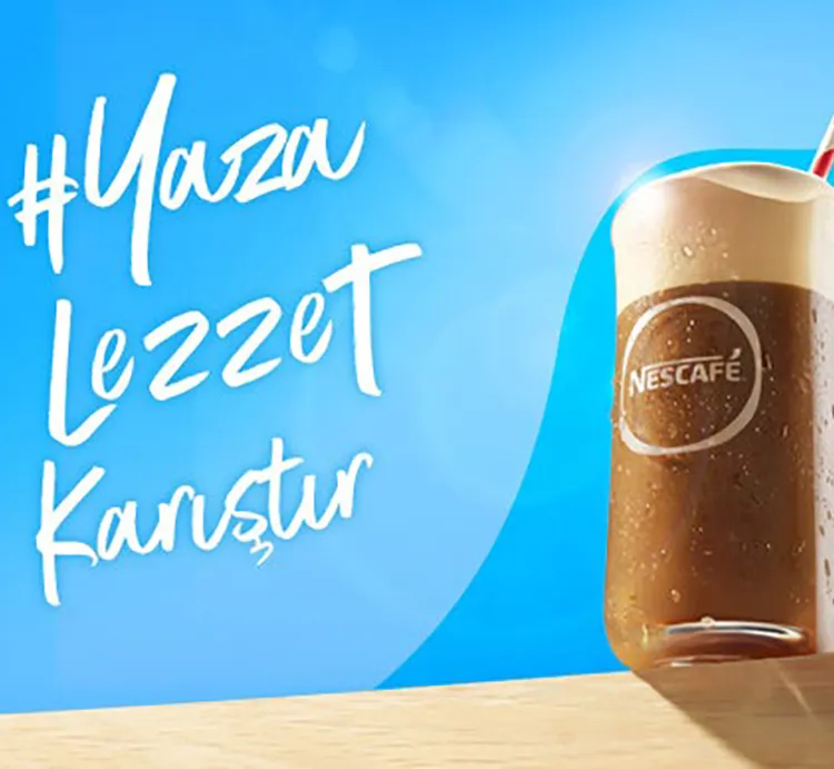 Masanın üzerinde NESCAFÉ Frappé bardağı