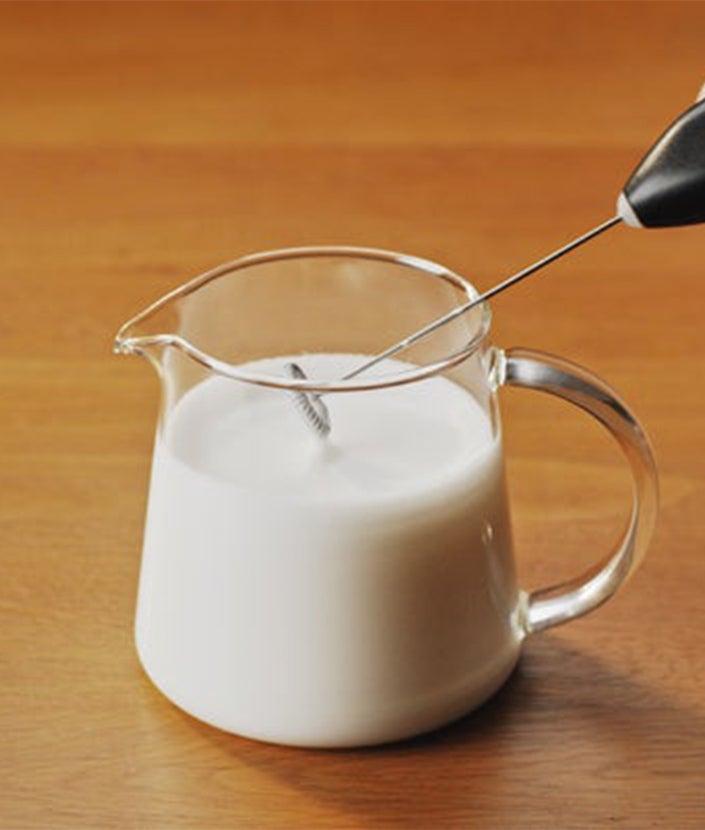 Спінене гаряче молоко  за допомогою спінювача у склянці
