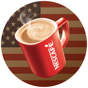 Una taza roja de Nescafé llena de café sobre una bandera estadounidense.