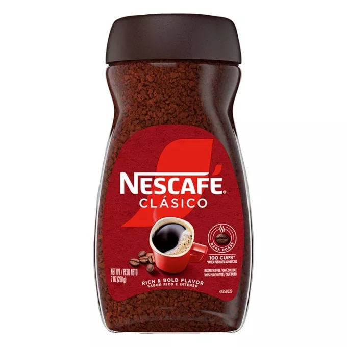 A jar of Nescafé Clásico Dark Roast with a black cap, brown label and red coffee mug.