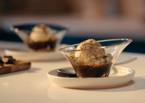 Fotografía de dos copas de cristal con helado sobre café oscuro, ambiente cálido