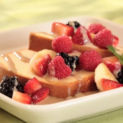 Photograph of thick toast slices topped with raspberries, blackberries and strawberries