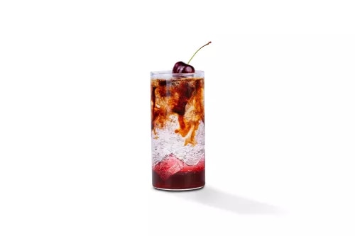 Photograph: tall cocktail glass with cola and cream swirling over ice, cherry garnish