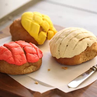 Fotografía de tres conchas mexicanas sobre tabla; coberturas roja, amarilla y beige