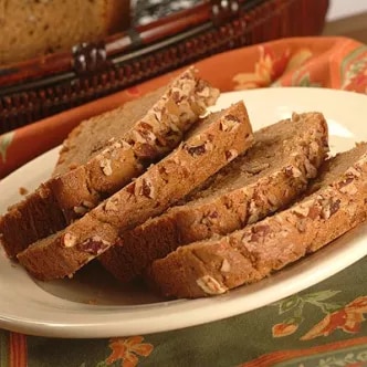 Fotografía: rebanadas de pan dulce con nueces en plato blanco sobre mantel estampado