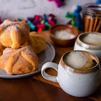 Fotografía: conchas de pan dulce en plato y dos tazas de café espumoso