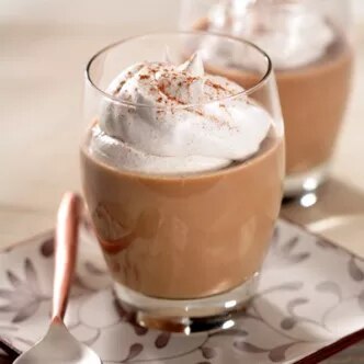 Fotografía: dos vasos con café con leche espumosa y canela sobre platillo decorado