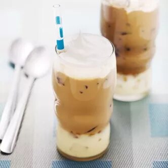 Fotografía de dos vasos de café helado con espuma y capa cremosa, uno con sorbete azul.