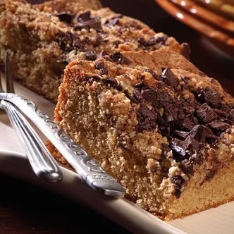 Photograph of two crumb-topped coffee cake slices with chocolate shavings on a plate